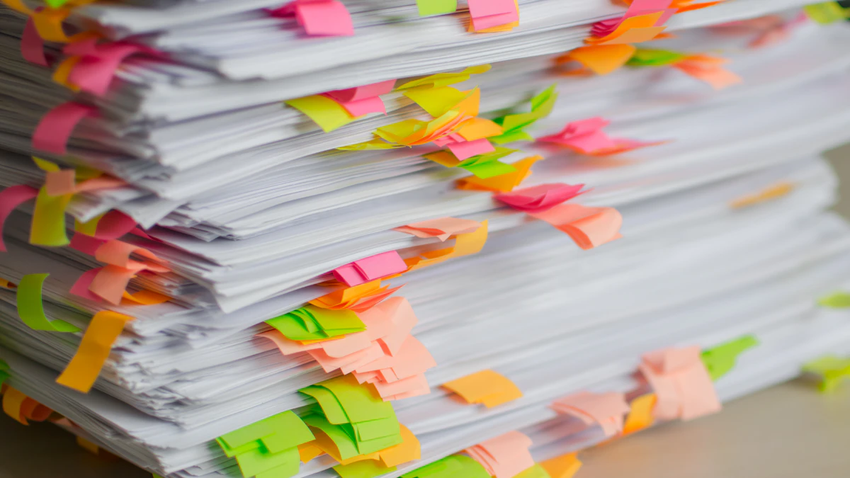 Printed documents marked with coloured sticky tabs on a desk, ready for review