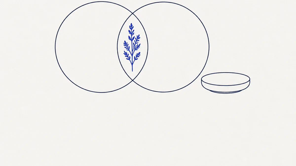 Two overlapping circles drawn in navy line, with a single cobalt herb sprig in the space where they overlap and a small round dish beside them