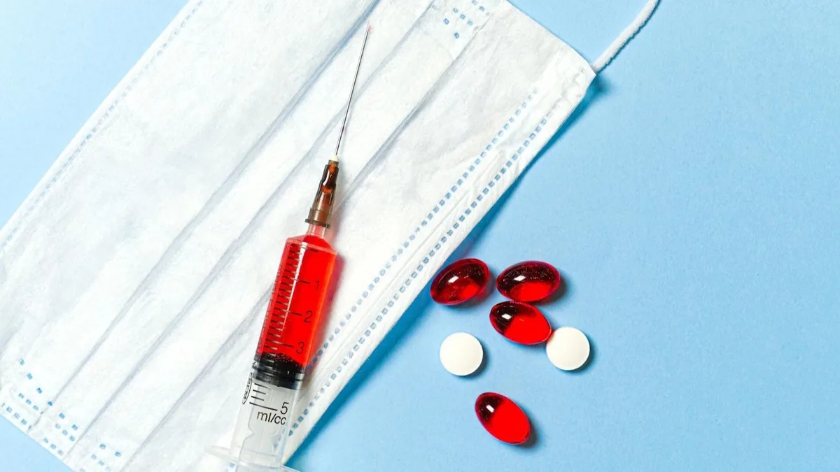 A syringe and pills on a blue background, illustrating prescription medicine advertising rules